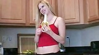 Blonde poses infront of camera while eating banana